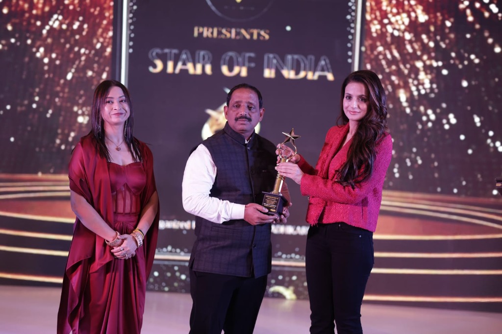 Ameesha Patel presenting golden Star of India trophy to awardee on stage